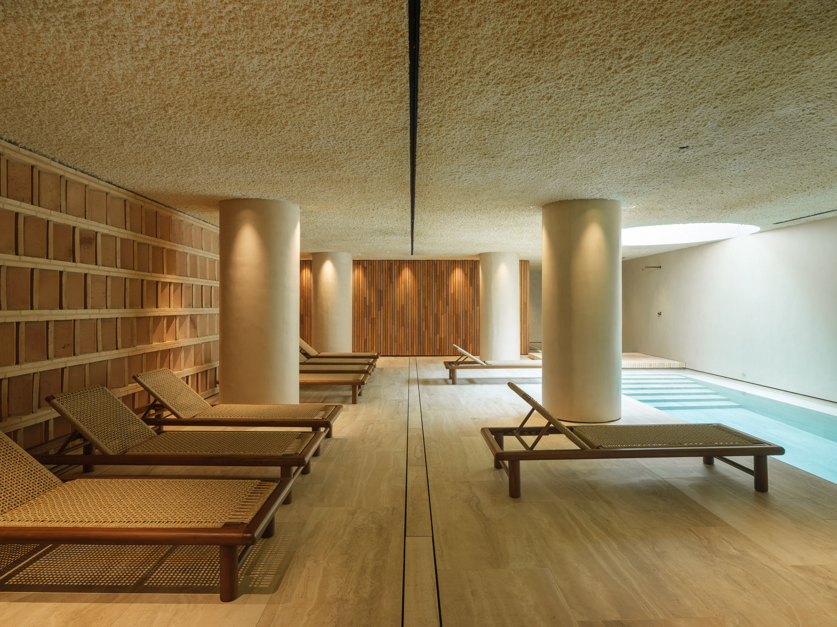 Interior d'un SPA d'hotel reformat al Maresme per a [Nom del teu Despatx]. Disseny arquitectònic minimalista amb llum zenital, tons càlids i materials naturals per a la zona d'aigües.