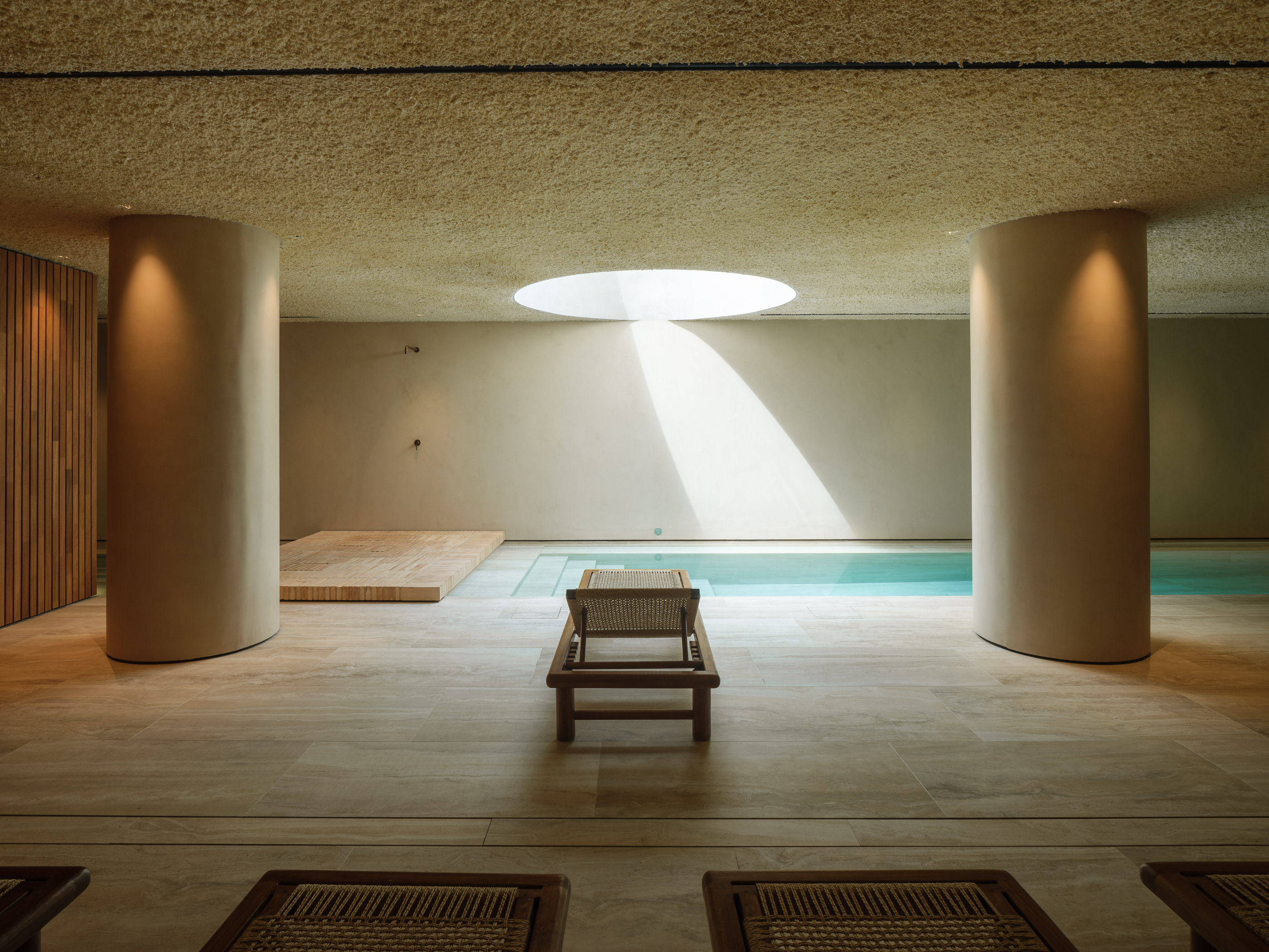 Interior d'un SPA d'hotel reformat al Maresme per a [Nom del teu Despatx]. Disseny arquitectònic minimalista amb llum zenital, tons càlids i materials naturals per a la zona d'aigües.