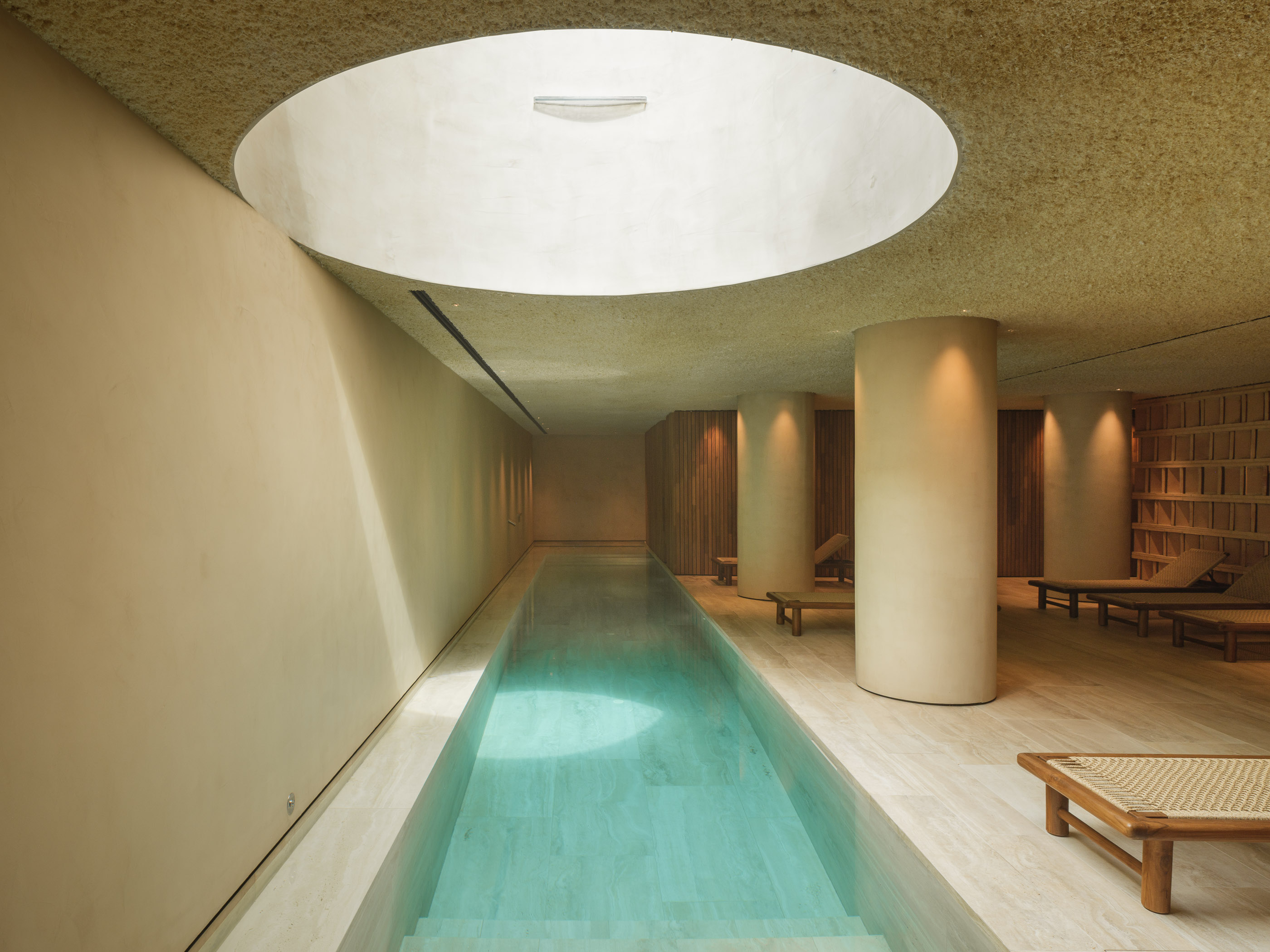 Interior d'un SPA d'hotel reformat al Maresme per a [Nom del teu Despatx]. Disseny arquitectònic minimalista amb llum zenital, tons càlids i materials naturals per a la zona d'aigües.