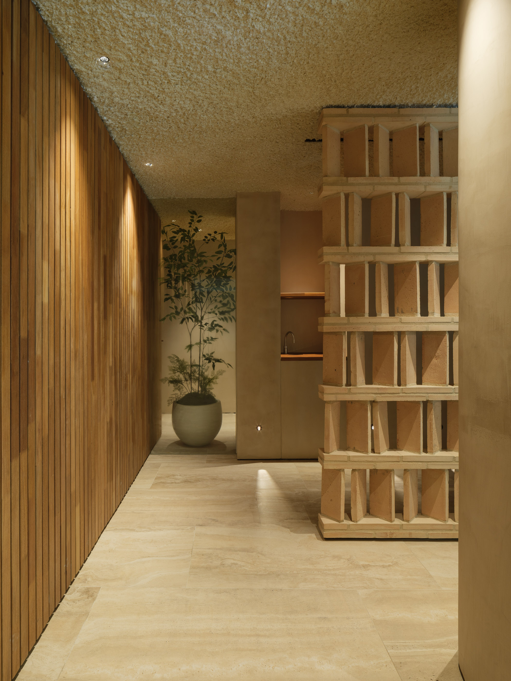 Interior d'un SPA d'hotel reformat al Maresme per a [Nom del teu Despatx]. Disseny arquitectònic minimalista amb llum zenital, tons càlids i materials naturals per a la zona d'aigües.