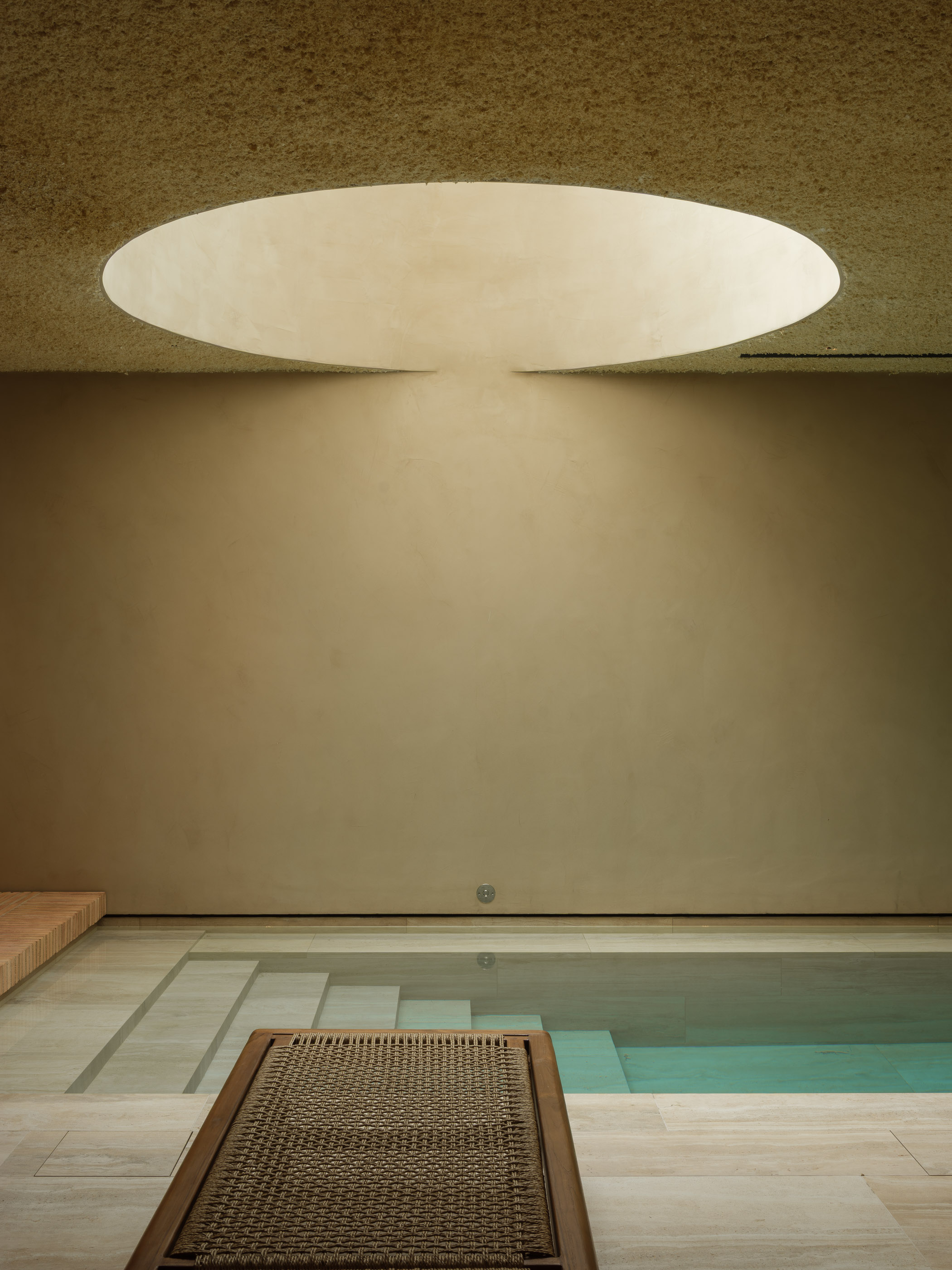 Interior d'un SPA d'hotel reformat al Maresme per a [Nom del teu Despatx]. Disseny arquitectònic minimalista amb llum zenital, tons càlids i materials naturals per a la zona d'aigües.